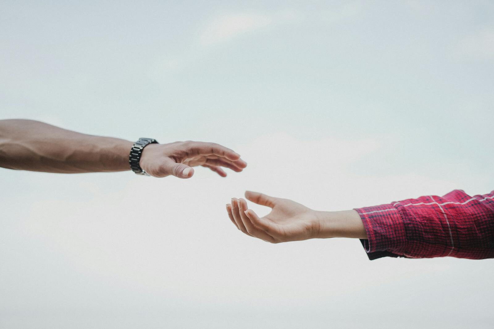 Two hands reaching towards each other, symbolizing connection and support.